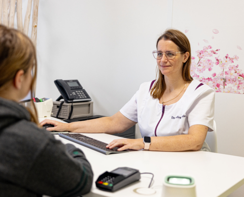 Photo de la docteure Lefrançois en pleine consultation pour un examen de body mapping dans l'objectif de recherche de mélanome
